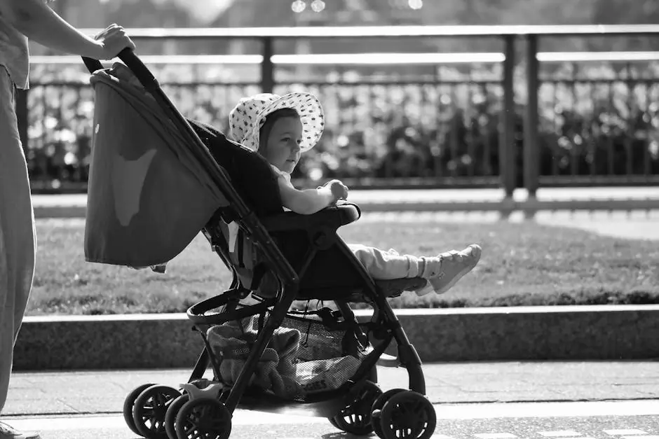 pexels-photo-18868554-18868554 Adorable baby in a sun hat enjoys a stroll in a stroller, black and white urban setting.