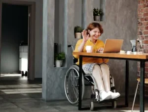 坐在輪椅上的女性，在無障礙的旅館享受遠端工作和視訊通話。